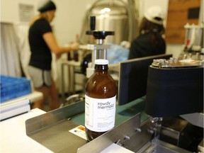 In this Oct. 6, 2015 photo, employees work on a bottling run of Living Ginger, one of several kombucha varieties produced at Rowdy Mermaid, a kombucha manufacturer in Boulder, Colo. The tangy, probiotic fermented tea called kombucha has moved from America's natural foods aisle to the mainstream.