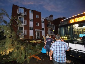 Residents board buses after apartment buildings had roofs torn off and windows blown out after a tornado caused extensive damage to a Gatineau, Quebec on Friday, September 21, 2018.