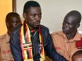 In this Thursday, Aug. 23, 2018 file photo, Ugandan pop star-turned-lawmaker Kyagulanyi Ssentamu, also known as Bobi Wine, centre, arrives at a magistrate's court in Gulu, northern Uganda.