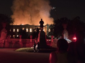 People watch as flames engulf the 200-year-old National Museum of Brazil, in Rio de Janeiro, Brazil, Sunday, Sept. 2, 2018. According to its website, the museum has thousands of items related to the history of Brazil and other countries. The museum is part of the Federal University of Rio de Janeiro