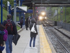 Passengers wait for a commuter train at Mount-Royal station, on its way to Deux-Montagnes on Monday May 11, 2015.