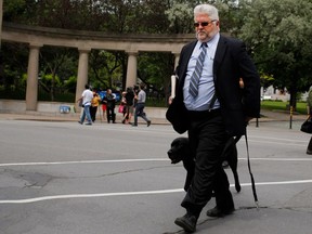 Brent Tyler and his dog Johnny leave a press conference after he reacted to the proposed Quebec sign law changes in Montreal Wednesday June 17th 2015.