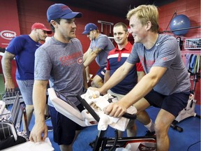The Canadiens' Andrew Shaw (left) chats with teammate Artturi Lehkonen as he rides a stationary bike on the first day of training camp at the Bell Sports Complex in Brossard on Sept. 13, 2018.