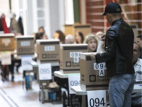 A voter casts his ballot in Westmount–St-Louis riding for the Quebec provincial election on Monday Oct. 1, 2018.