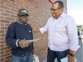 Liberal candidate Saul Polo, right, speaks with Luis Alice while campaigning Laval-des-Rapides.