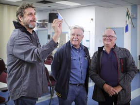 LaSalle Legion president Ray Comrie and first vice president Bruce Allan, right, watch as comedian Joey Elias throws darts at the Lasalle legion where he will perform in a legion fundraiser later this month.  (John Mahoney / MONTREAL GAZETTE)