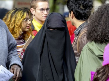A woman wearing a niqab takes part in an antiracism demonstration through the streets of Montreal on Sunday, Oct. 7, 2018.