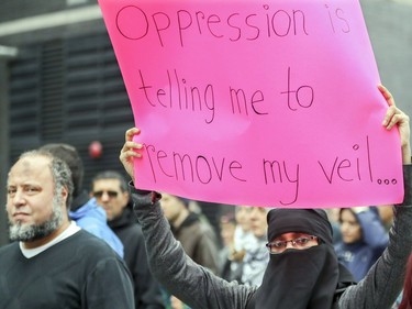 A woman holds up a sign during an antiracism demonstration through the streets of Montreal on Sunday, Oct. 7, 2018.