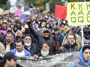 A marcher raises a fist as anti-racism demonstration makes its way up Peel St. in Montreal on Sunday, Oct. 7, 2018.