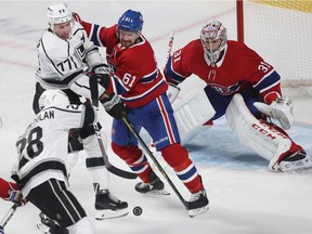 Montreal Canadiens defenceman Xavier Ouellet gets in front of Los Angeles Kings' Jeff Carter (77) and Jaret Anderson-Dolan (28) while goaltender Carey Price keeps his eyes on the puck during first period in Montreal on Thursday, Oct. 11, 2018.