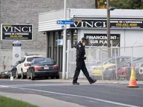 Police secure the area around the site of an overnight murder in Laval, Oct. 12, 2018.