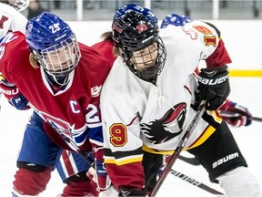 Montreal Canadiennes captain Marie-Philip Poulin and Calgary Inferno's Brianne Jenner at a face-off during a 3-1 loss to Calgary at Place Bell in Laval on Sunday October 14, 2018.