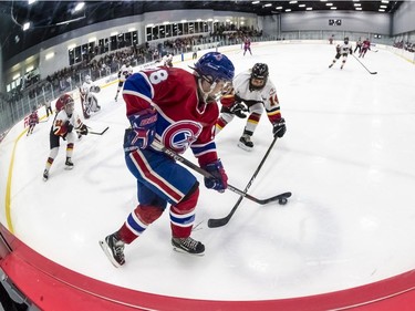 Montreal Canadiennes' Tracy-Ann Lavigne is covered by Calgary Inferno's Brianna Decker (14) during a 3-1 loss to the Calgary at Place Bell in Laval on Sunday October 14, 2018.