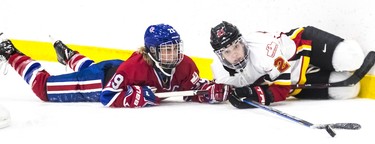 Montreal Canadiennes captain Marie-Philip Poulin and Calgary Inferno's Halli Krzyzaniak watch the puck get away from them during a 3-1 loss to Calgary at Place Bell in Laval on Sunday October 14, 2018.
