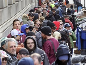 People line up on Metcalfe St. around the corner from the Société québécoise du cannabis store on Ste-Catherine St. W. in Montreal Oct. 17, 2018.