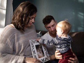 Hannah Aubut and her husband, Scott, are seen with their child Cyan on Friday, Oct. 19, 2018. Hannah holds a photo of her deceased child, Senna.