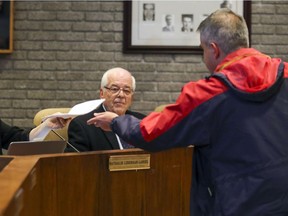 Beaconsfield Mayor Georges Bourelle watches as resident Daniel Mongeau presents a petition protesting recent pay raises for the mayor and councillors.