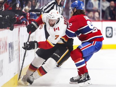 Jonathan Drouin checks Calgary Flames TJ Brodie during second period in Montreal Tuesday, Oct. 23, 2018.