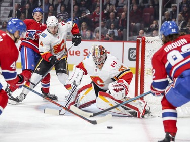 Montreal Canadiens Joel Armia, left, and Jonathan Drouin converge on loose puck in front of Calgary Flames goalie David Rittich during first period in Montreal Tuesday, Oct. 23, 2018.  Habs Jesperi Kotkaniemi is boxed out by Flames defenceman Rasmus Andersson at rear.