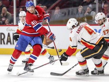 Montreal Canadiens Joel Armia takes a shot on net while being surrounded by Calgary Flames Matthew Tkachuk, left rear, Rasmus Andersson and Michael Frolik during first period in Montreal Tuesday, Oct. 23, 2018.