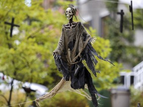 A skeleton flies over a cemetery Halloween display in Lachine.