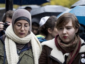 Sarah Abdelshamy, left, and Tali Ioselevich stand arm in arm during vigil in Montreal Sunday, Oct. 28, 2018 for victims of the shootings at the Tree of Life congregation in Pittsburgh Pennsylvania.
