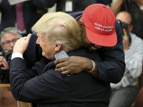 U.S. President Donald Trump hugs rapper Kanye West during a meeting in the Oval office of the White House on October 11, 2018 in Washington, DC.