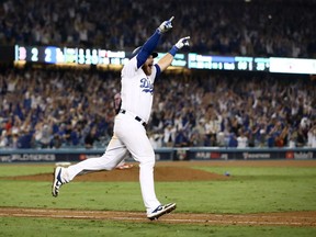 Max Muncy #13 of the Los Angeles Dodgers celebrates his eighteenth inning walk-off home run to defeat the the Boston Red Sox 3-2 in Game Three of the 2018 World Series at Dodger Stadium on October 26, 2018 in Los Angeles, California.