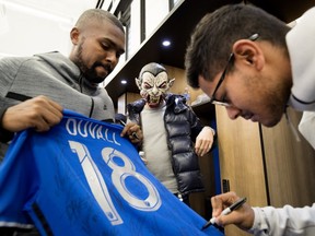 Montreal Impact's Chris Duvall, left, gets his jersey signed by Shamit Shome as James Pantemis looks on in a Halloween costume as players cleared out their lockers in Montreal on Wednesday, Oct. 31, 2018.