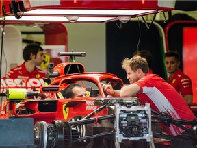Sebastian Vettel consults with team members in the Ferrari garage ahead of Friday practice for the Mexican Grand Prix.