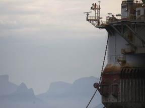 A worker is perched on a Petrobras oil platform floating in the Atlantic Ocean near Guanabara Bay in Brazil.