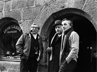 Charles Aznavour (right) talks with French actor Michel Serrault (centre) and director Claude Chabrol in Concarneau, on the set of the film Les fantome du chapelier in 1982.