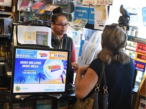 Customers buy Mega Millions tickets hours before the draw of the  USD 1 billion jackpot, at the Bluebird Liquor store in Torrance, California on October 19, 2018.