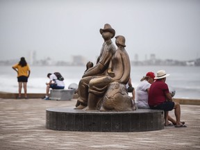 Tourist sit by the Malecon (boardwalk) in Mazatlan, Mexico, Oct. 22 2018, before the arrival of Hurricane Willa.