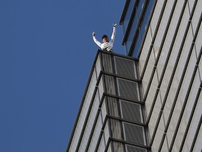 TOPSHOT - French urban climber Alain Robert, also known as "Spider-Man", reacts as he reaches the top of Heron Tower, 110 Bishopsgate, in central London on October 25, 2018, the tallest tower in the city of London.