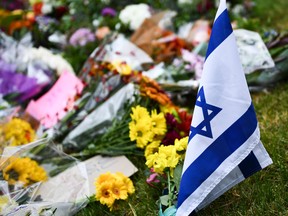 An Israeli national flag is seen at a memorial on Sunday, Oct. 28, 2018, down the road from the Tree of Life synagogue after a shooting there left 11 people dead in the Squirrel Hill neighbourhood of Pittsburgh on Saturday, Oct. 27, 2018.