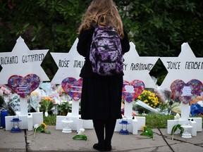 A woman stands at a memorial outside the Tree of Life synagogue after a shooting there left 11 people dead in the Squirrel Hill neighbourhood of Pittsburgh on Oct. 27, 2018 .