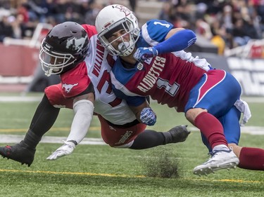 Montreal Alouettes defensive back drives into Calgary Stampeders running back Terry Williams during second-half CFL action at Molson Stadium in Montreal on Monday, Oct. 8, 2018.