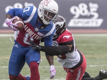 Montreal Alouettes running back Stefan Logan tries to evade Calgary Stampeders linebacker Wynton McManis during first-half CFL action at Molson Stadium in Montreal on Monday, Oct. 8, 2018.