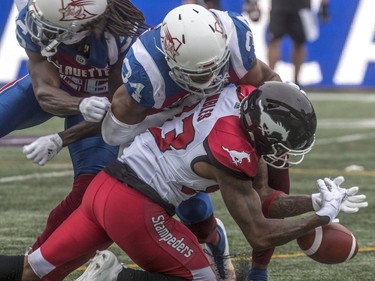 Calgary Stampeders wide receiver Markeith Ambles can't hang onto the ball with Montreal Alouettes linebacker Glenn Love above during first-half CFL action at Molson Stadium in Montreal on Monday, Oct. 8, 2018.