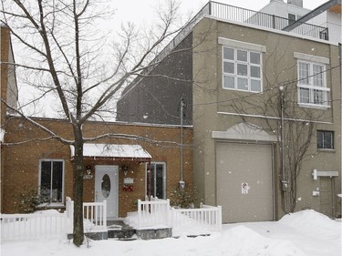 Snow falls lightly on St. Urbain street where former industrial buildings that have been converted to condos stand next to classic Shoebox style housing, left, in the Mile Ex district of Montreal on Thursday December 26, 2013.