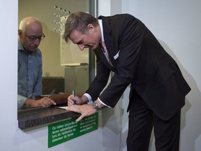 Maxime Bernier signs papers as he files the papers for the Peoples Party of Canada at the Elections Canada office in Gatineau on Oct. 10, 2018.