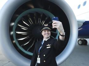 Delta line check pilot Jay Matthew Insalaco takes a selfie with a geared turbo fan engine while Delta unveils its A220 aircraft.