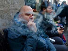 Hugo Senecal smokes marijuana at the head of the line waiting for the opening of the SQDC outlet on Ste-Catherine St. in Montreal Oct. 17, 2018.