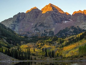 The first morning light hits the peaks of Maroon Bells in Aspen, Colo., Tuesday, Sept. 25, 2018. (Anna Stonehouse/The Aspen Times via AP) ORG XMIT: COAST201