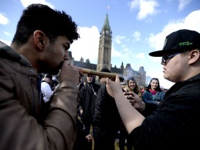 Statistics Canada says about two-thirds of casual cannabis users say they didn't spend anything on the drug in the past three months, chalking it up to a sharing culture among marijuana users. A man shares a his marijuana joint during the annual 4/20 marijuana celebration on Parliament Hill in Ottawa on Friday, April 20, 2018.