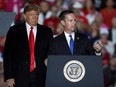 President Donald Trump listens as U.S. Rep. Rodney Davis, R-Ill, speaks during a rally at Southern Illinois Airport Saturday, Oct. 27, 2018, in Murphysboro, Ill.