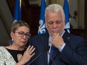 Quebec Premier and Liberal Leader Philippe Couillard pauses as he gets emotional while announcing his resignation as Premier and MNA for the riding of Roberval, Thursday, October 4, 2018 at the legislature in Quebec City. Couillard's wife Suzanne Pilote, left, comforts him.