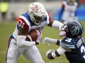 Montreal Alouettes running-back William Stanback blocks Toronto Argonauts defensive-back Alden Darby as he carries the ball up field during first half in Toronto on Oct. 20, 2018.