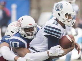 Toronto Argonauts quarterback James Franklin is tackled by Montreal Alouettes' Henoc Muamba during first half CFL football action in Montreal, Sunday, Oct. 28, 2018.